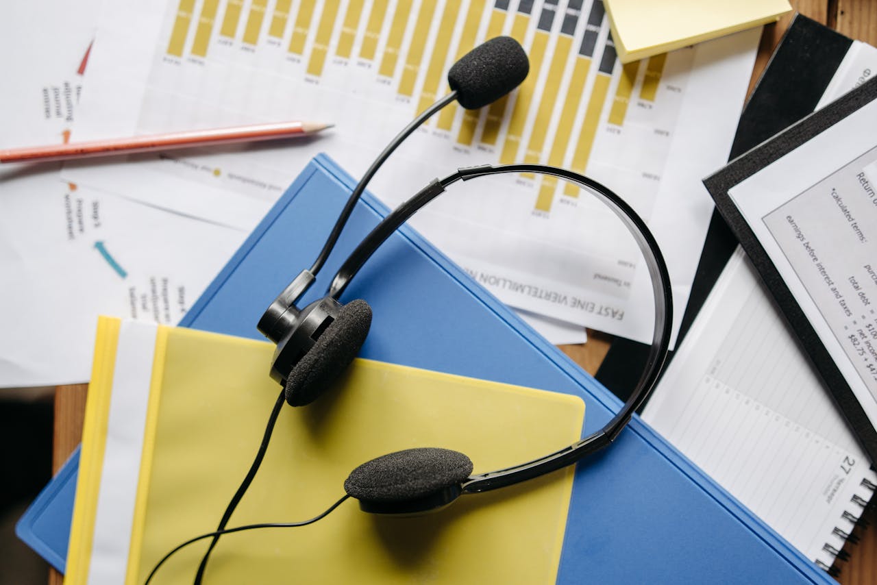 home-hero-bg Close-up of an office desk with headset, charts, and documents showcasing customer service support.